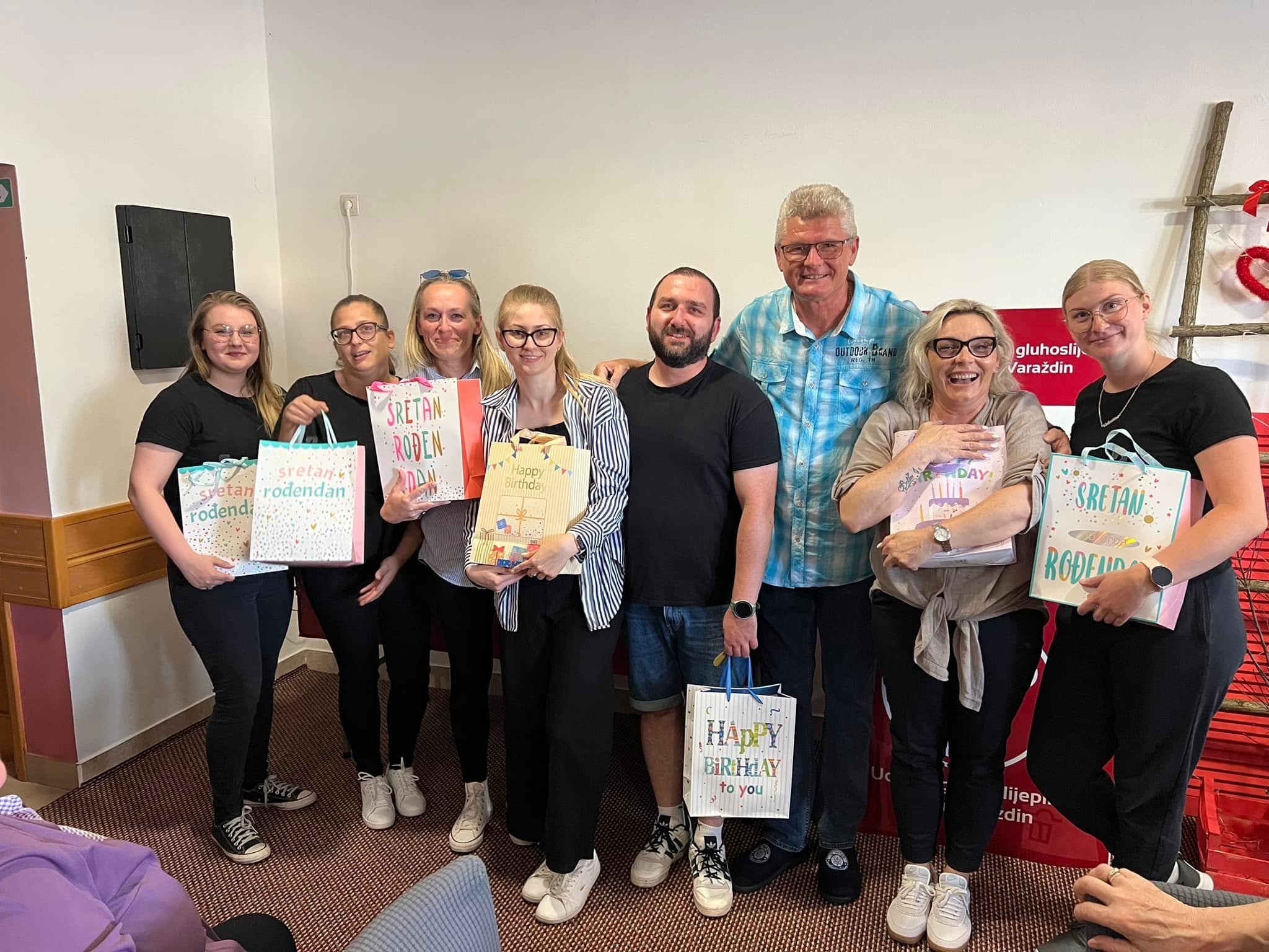 A group posing with birthday gift bags at UGSO Varaždin.