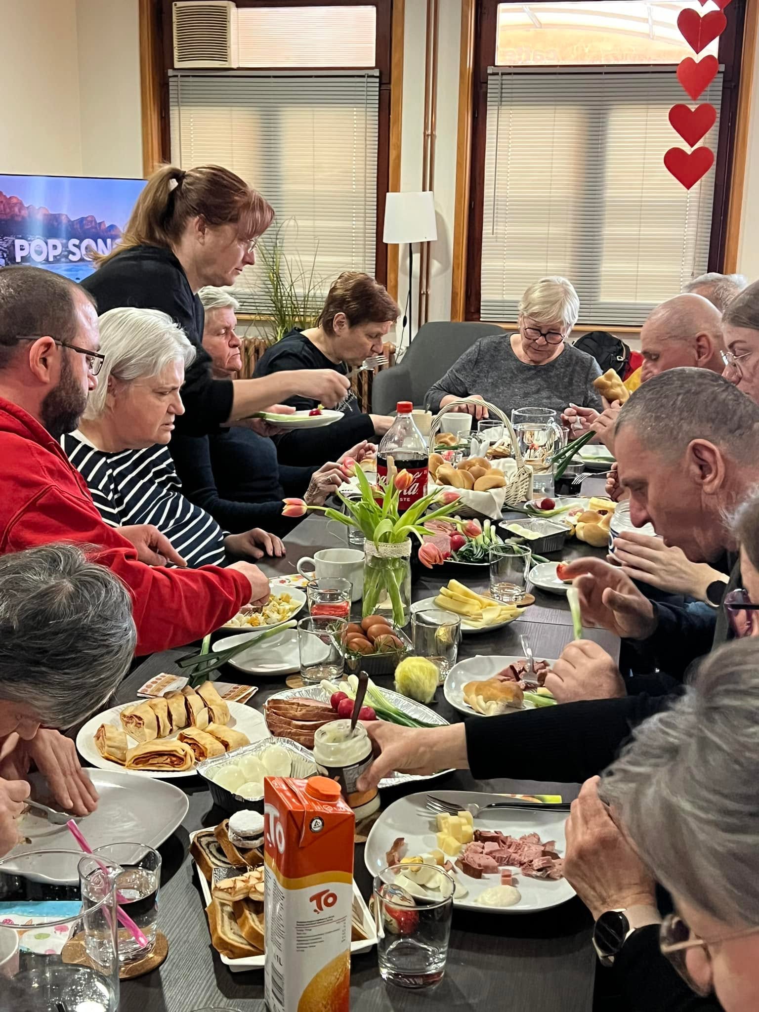 A group sharing a meal around a long table.