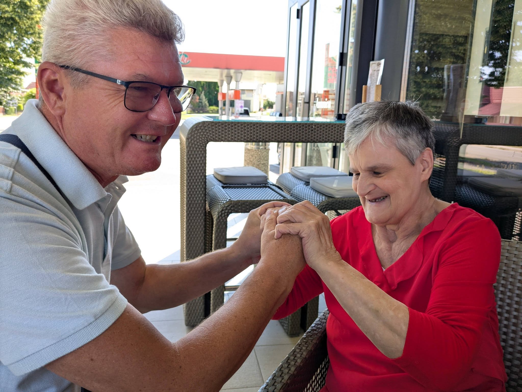 Two people seated together, communicating through their hands.