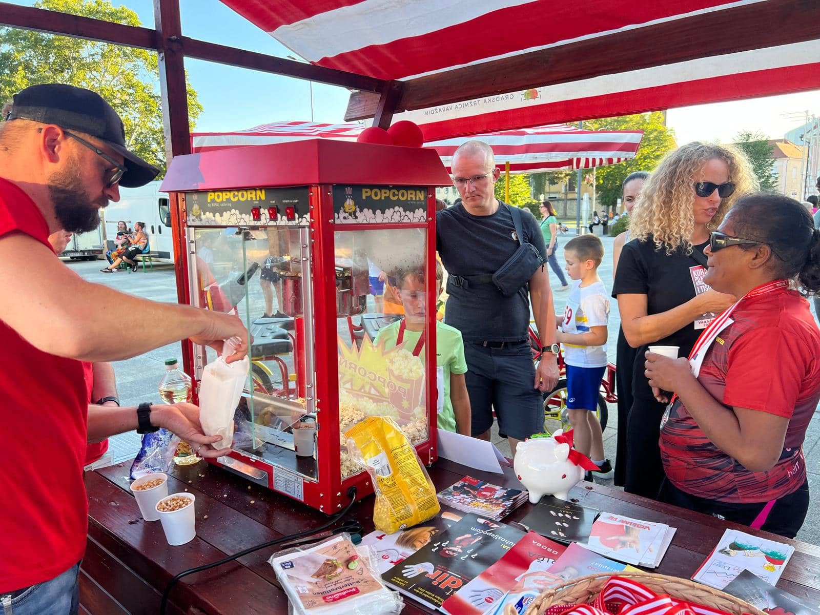 People gathering around a popcorn stand in the race area.