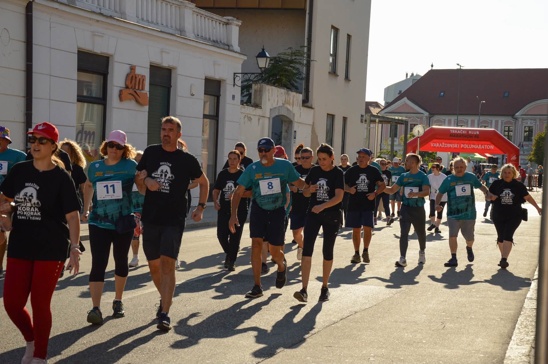 Pairs of participants and support people moving together away from the race start.
